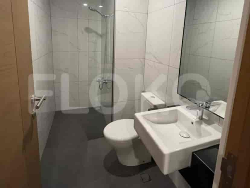 A modern bathroom with a walk-in shower, white toilet, and a wall-mounted sink.