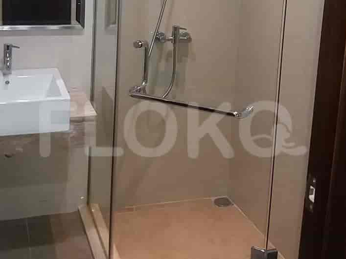 Kamar mandi yang ramping dengan pancuran berkaca.
