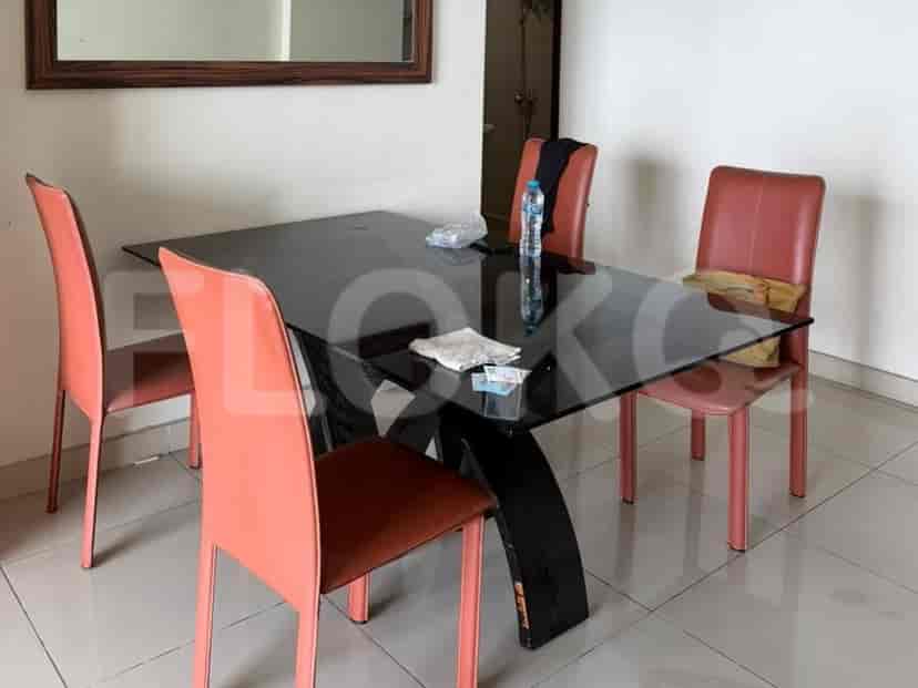 A dining room with a glass-top table and four chairs.