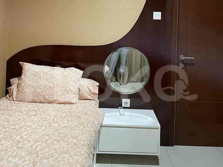 Bedroom with a single bed, round mirror, and a nightstand with a sink.