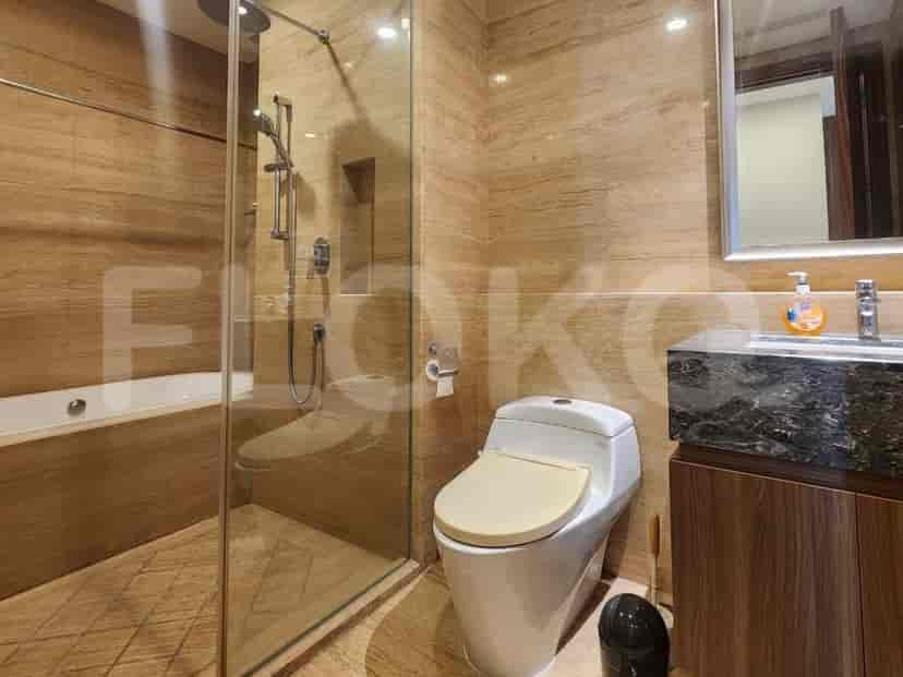 A modern bathroom with a bathtub, glass-enclosed shower, toilet, and vanity.