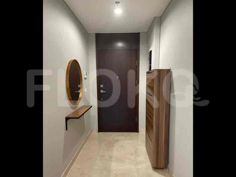 A hallway with a dark wooden door, a console table with a mirror, and a shoe cabinet.