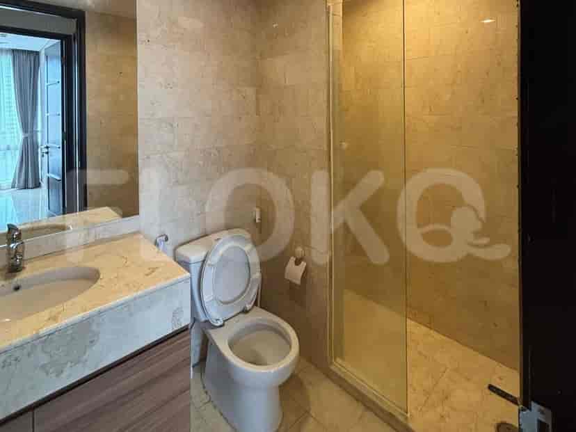 A bathroom featuring a marble vanity, toilet, and a glass-enclosed shower.