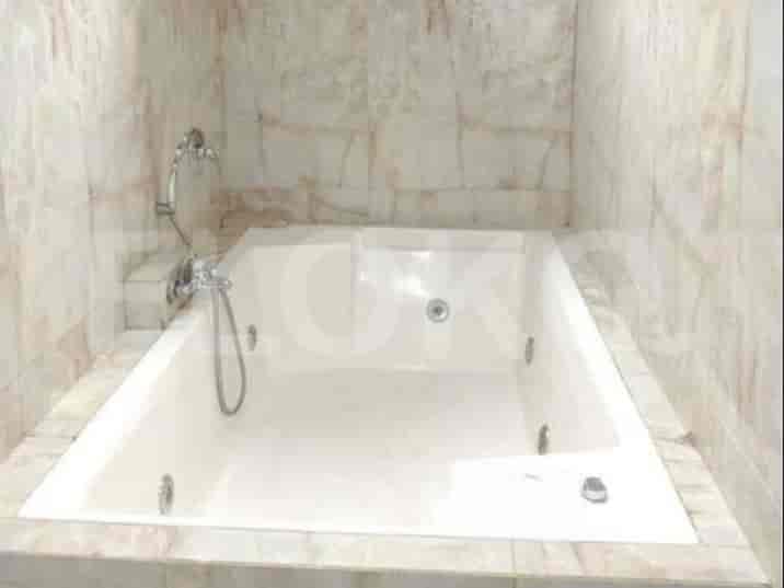 Bathroom with a white bathtub and marble tiles.