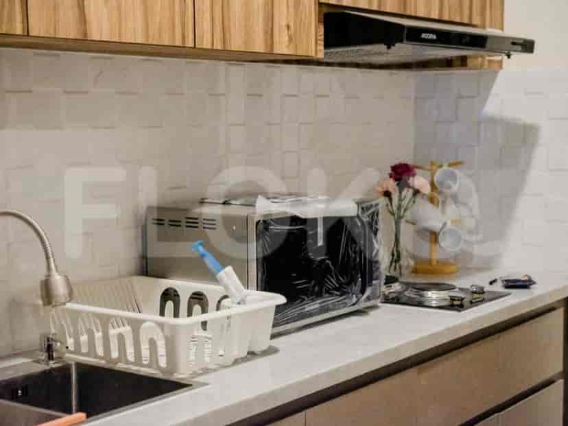A kitchen counter with a microwave, sink, and stovetop.