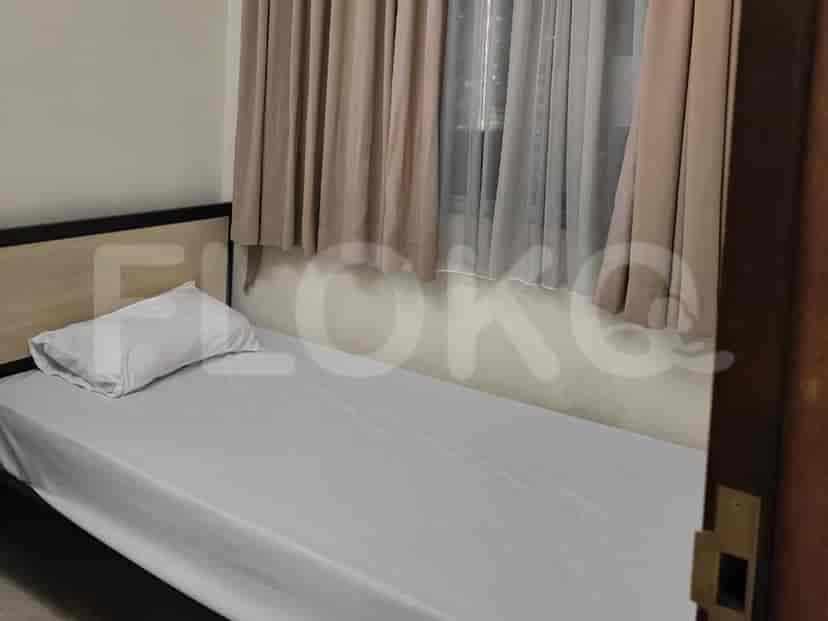 A bedroom with a single bed and beige curtains.