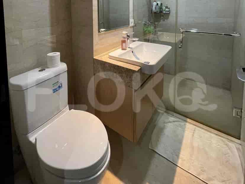 Kamar mandi yang terang dengan toilet, wastafel, dan pancuran.