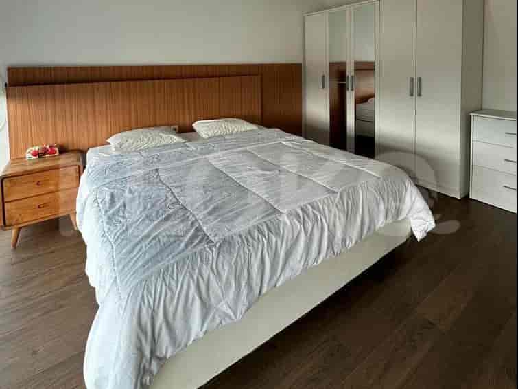 A bedroom with a bed, nightstand, and wardrobe.