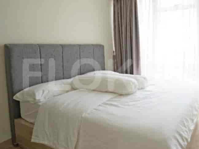 A bedroom with a large bed and a grey headboard.