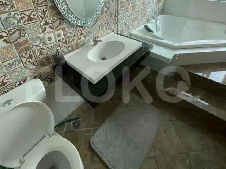 A bathroom with a sink, toilet, and bathtub, featuring patterned tiles.