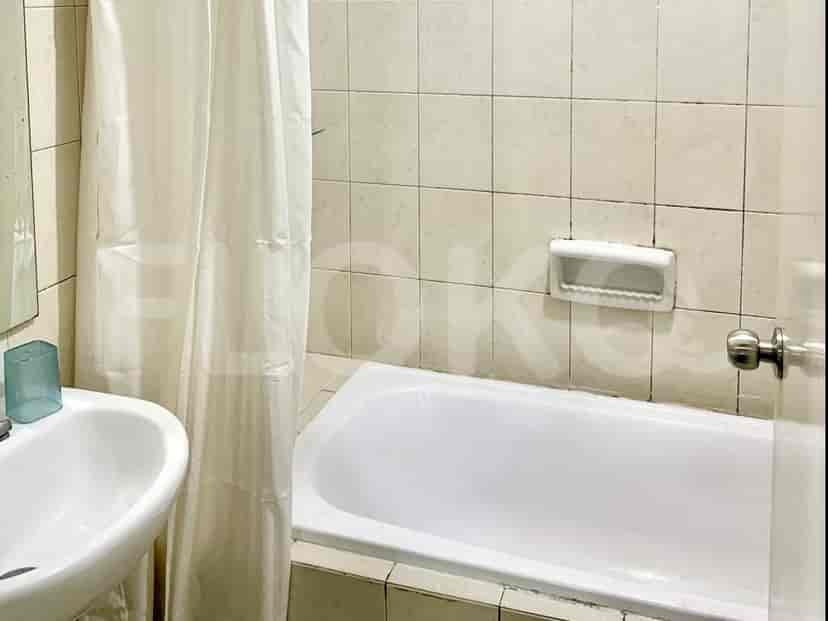 Kamar mandi dengan bak mandi, wastafel, dan gorden shower.