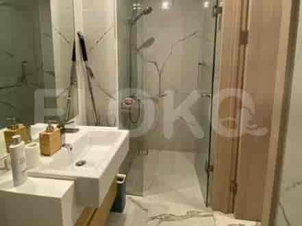 A bathroom with a sink, faucet, and a glass-enclosed shower.