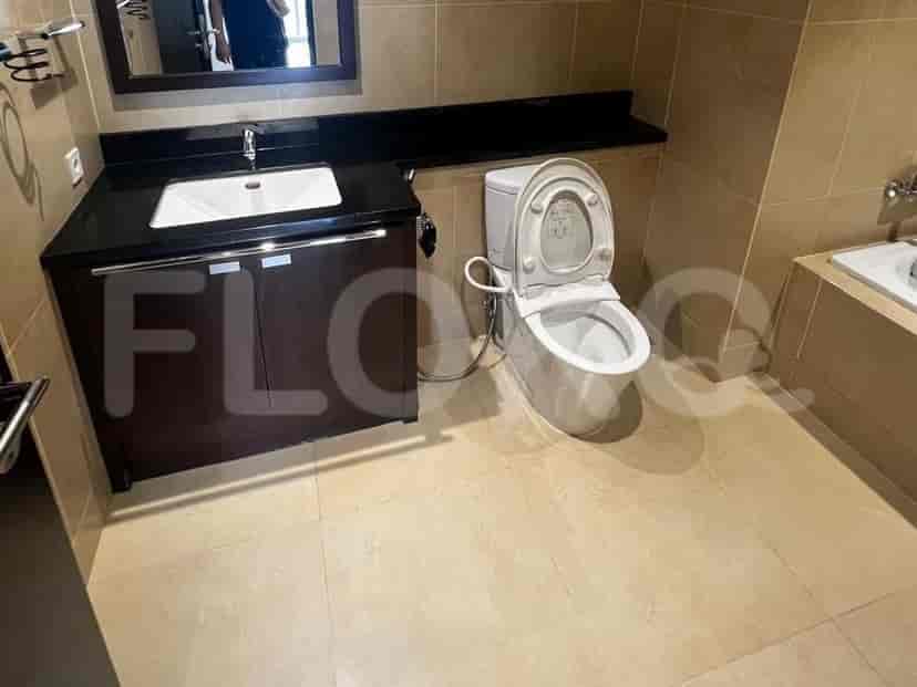 Kamar mandi dengan meja rias, toilet, dan bak mandi, menampilkan dinding dan lantai berubin krem.