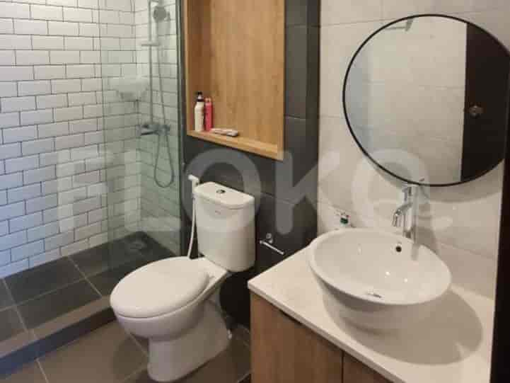 Kamar mandi modern dengan toilet putih, wastafel mangkuk, shower walk-in dengan ubin subway putih, dan cermin bulat.