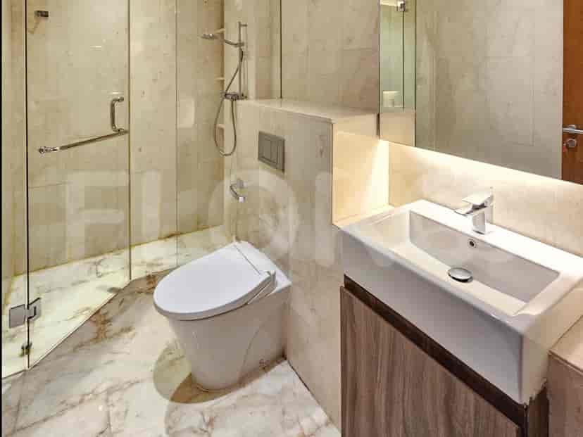 Kamar mandi modern dengan pancuran dan toilet.