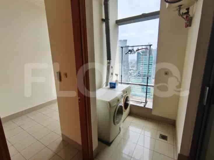 A small laundry room with a washing machine, dryer, and a window overlooking the city.
