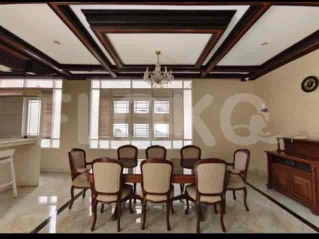 A formal dining room with a large wooden dining table, chairs, and a decorative chandelier.
