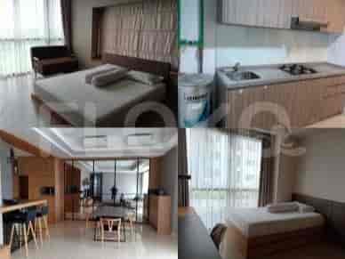 Bedroom with a double bed, kitchen area with wooden cabinets and a gas stove.