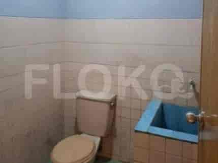 Bathroom with a toilet, sink, and tiles on the wall.