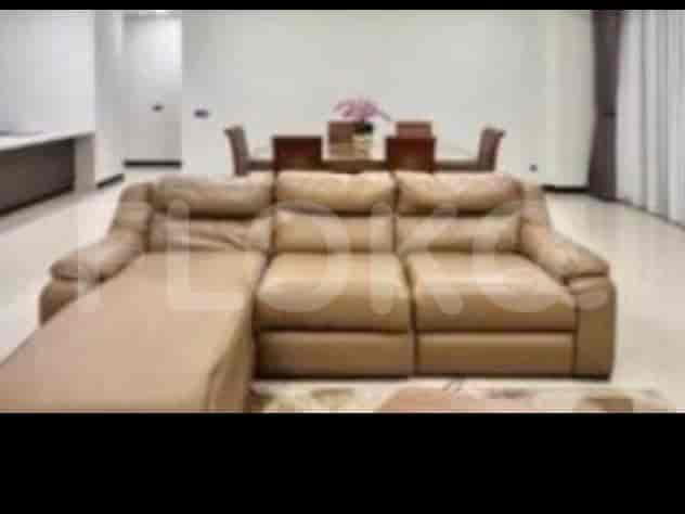 A spacious living room with an L-shaped leather sofa facing a dining area.