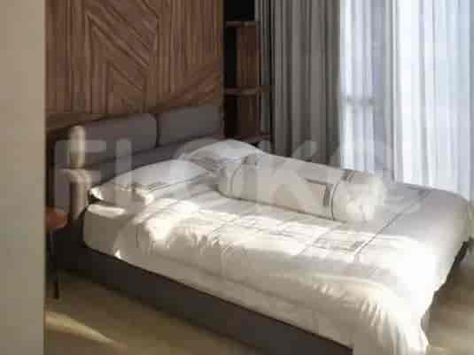 A bedroom with a king-size bed, bedside table, and wooden accent wall.