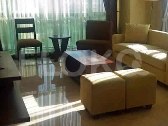 A living room with a sofa, armchairs, coffee table, and window with curtains.