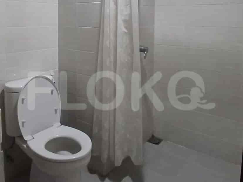 A small bathroom with a toilet and shower area.
