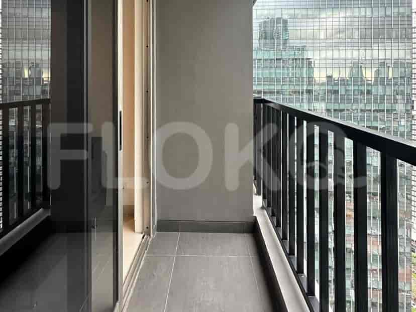 A balcony with a black railing and a view of the city.