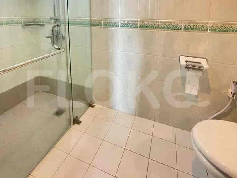 A modern bathroom with a glass shower enclosure and white toilet.