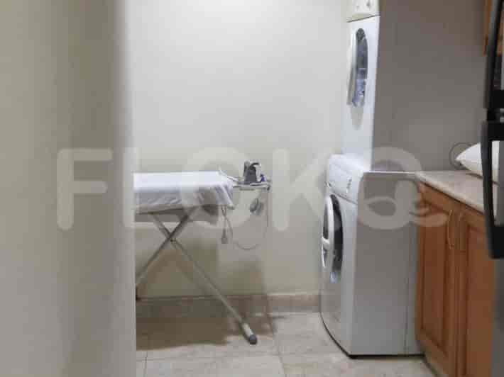A laundry room with a washing machine, dryer, and ironing board.