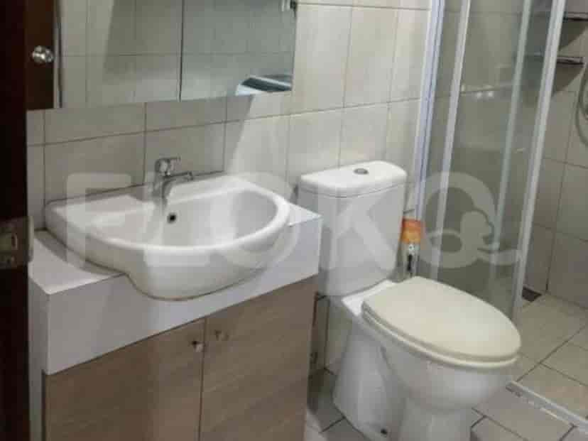 A bathroom with a white sink, toilet, and a glass-enclosed shower.