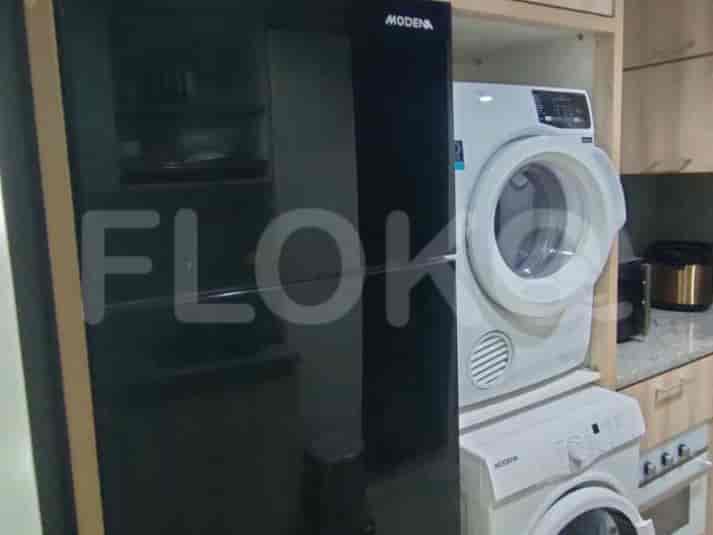 Close-up view of the fridge and washing machine in the kitchen.