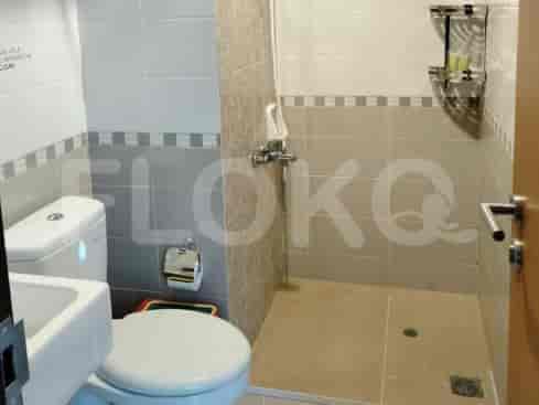 A functional bathroom with a toilet, sink, and a standing shower area.