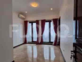 A spacious living room with large windows and red curtains.