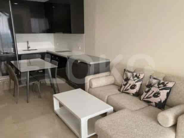 A modern studio apartment featuring an open kitchen and a small dining table adjacent to a cozy living area.