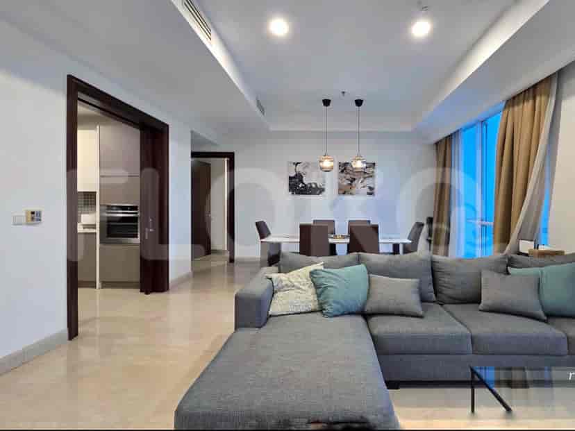 A combined living and dining area with a large sectional sofa, dining table, and large windows.