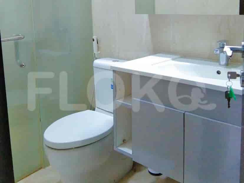 A compact bathroom with a toilet and a white sink vanity.