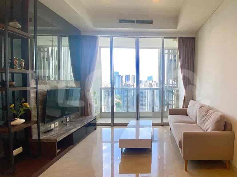 A modern living room with a sofa, TV, and large windows offering a city view.