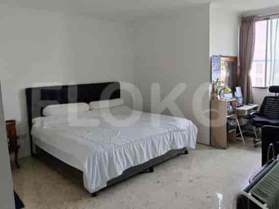 A bedroom with a large bed, desk, and window.