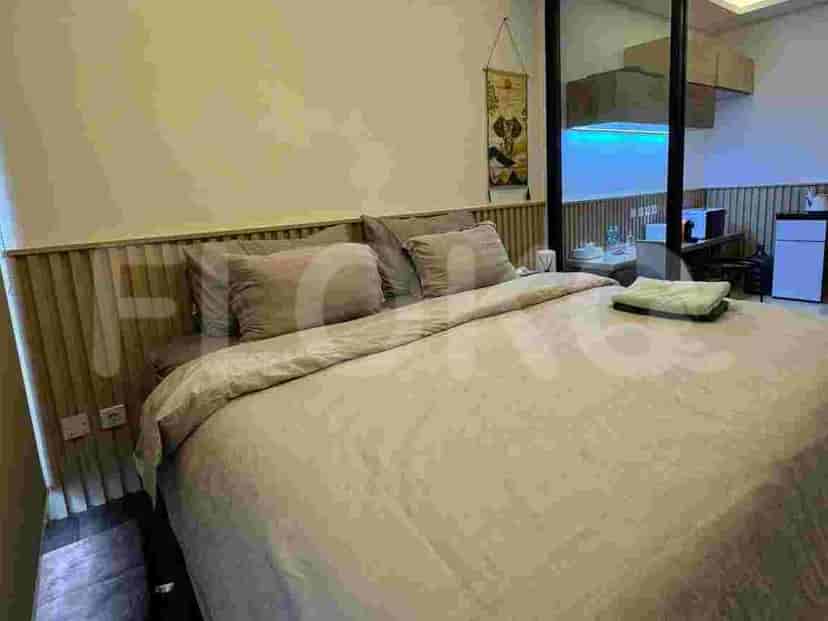 A bedroom with a large bed, bedside tables, and a wooden headboard.