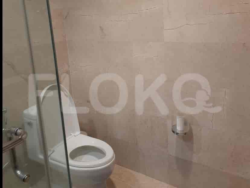 Kamar mandi dengan toilet modern dan bilik pancuran kaca.
