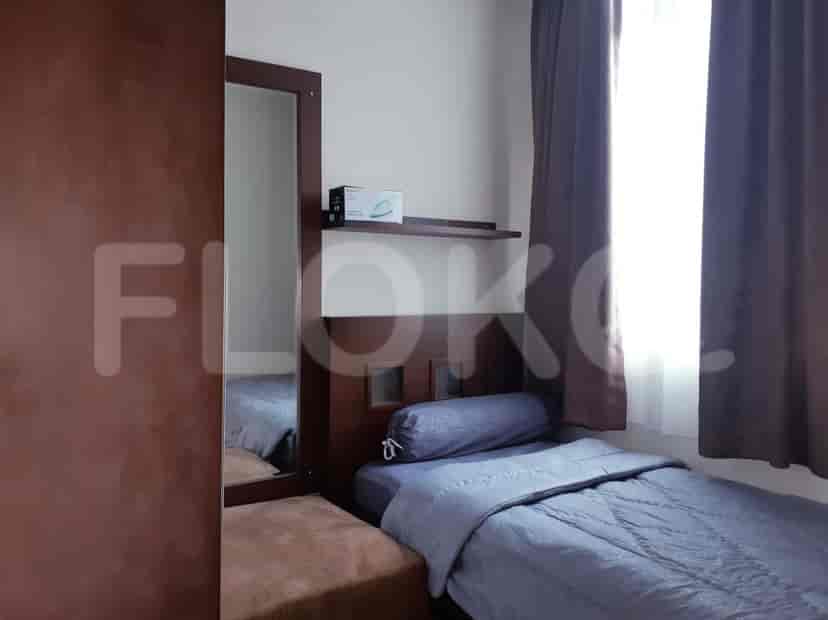A bedroom with a single bed, a wardrobe, and a full-length mirror.