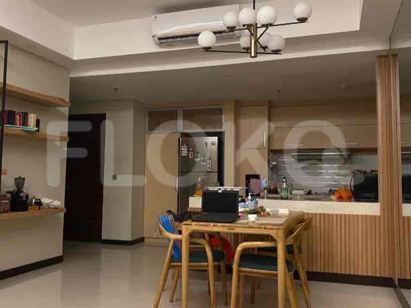 Area dapur dan ruang makan gabungan dengan lemari kayu, meja makan, dan kulkas.