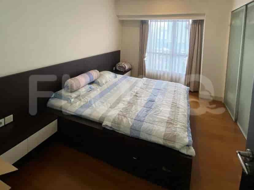 A bedroom with a queen-size bed, bedside tables, and a window.