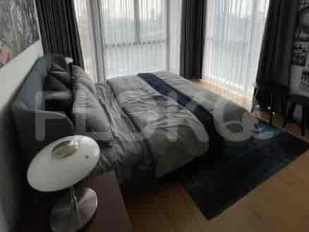 A bedroom featuring a large bed with striped bedding and a dark grey headboard.