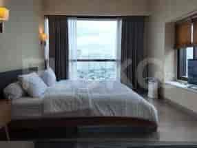 A modern bedroom with a king-size bed, wooden accents, and a large window.