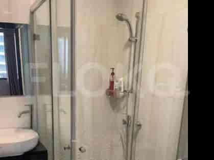 A bathroom featuring a shower stall, sink, and faucet.