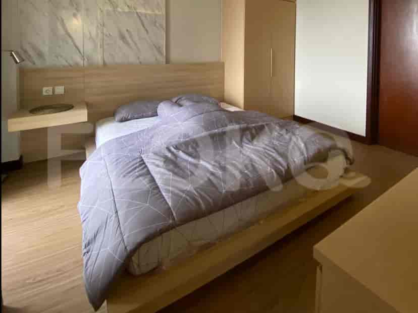 Cozy bedroom with a queen-size bed and wooden flooring.