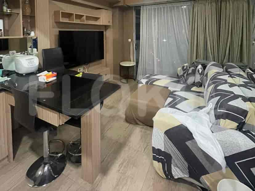 A living and dining area with a black dining table, chairs, sofa, and a TV.