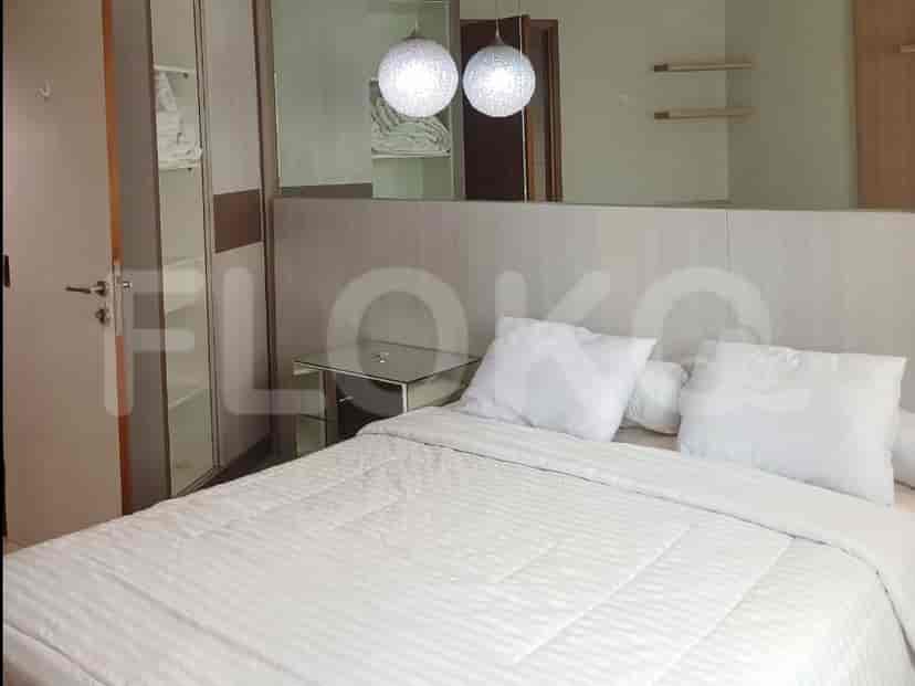 Bedroom with bed, mirrored wall, and closet.